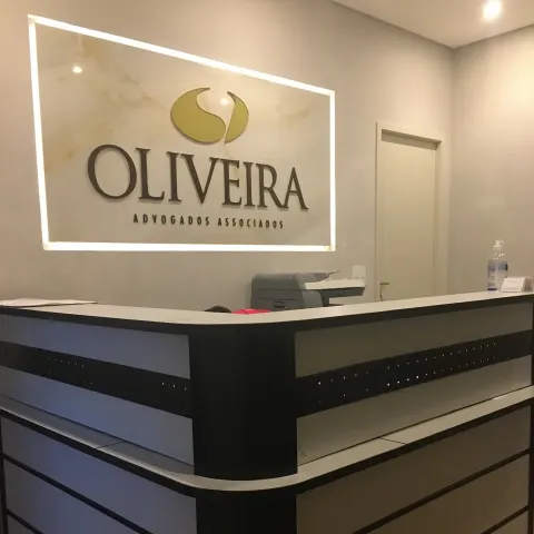 Recepção de escritório com balcão e logotipo iluminado na parede